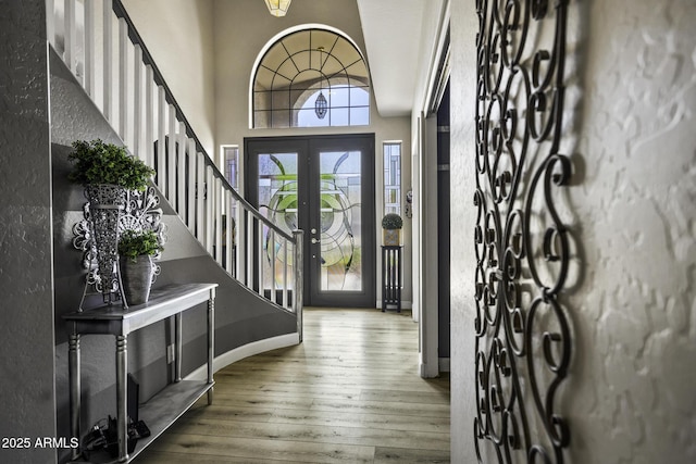 foyer entrance featuring stairs, a textured wall, and hardwood / wood-style floors