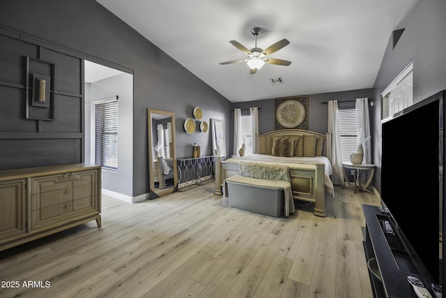 bedroom with ceiling fan, visible vents, vaulted ceiling, baseboards, and light wood-style flooring