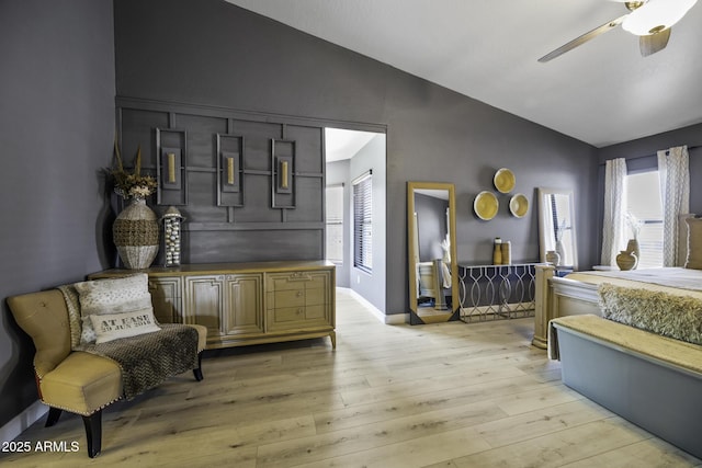bedroom with a ceiling fan, baseboards, lofted ceiling, and light wood-type flooring