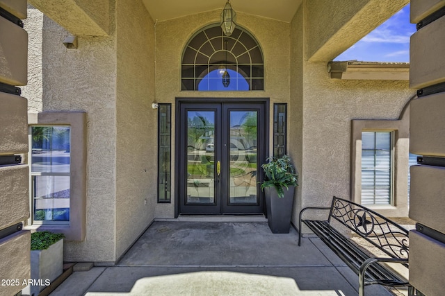 entrance to property with stucco siding and french doors