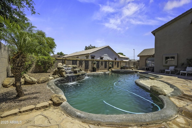 view of pool featuring a fenced backyard, a pool with connected hot tub, and a patio area