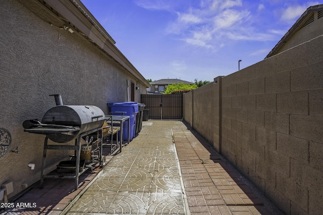 view of patio featuring fence and a gate