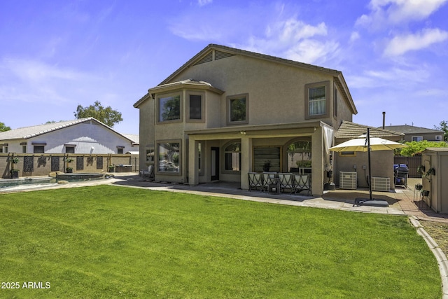 rear view of house with a patio, a fenced backyard, a lawn, and stucco siding