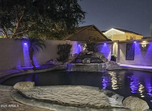 pool at twilight featuring fence and a pool