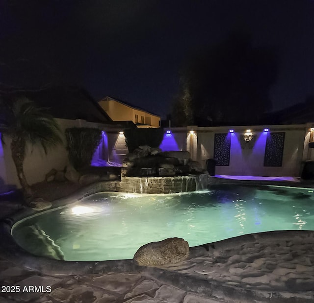 pool at night with an outdoor pool
