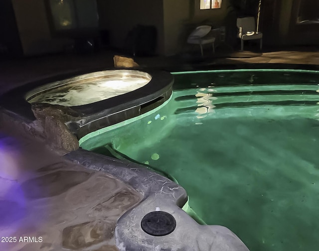 view of swimming pool with an in ground hot tub