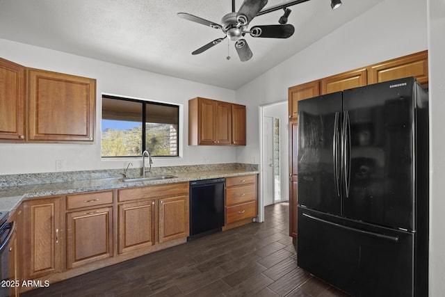 kitchen with light stone counters, ceiling fan, sink, black appliances, and lofted ceiling