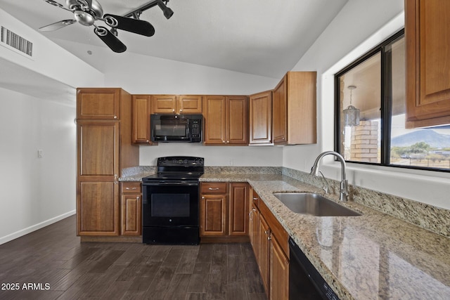 kitchen with light stone countertops, sink, black appliances, dark hardwood / wood-style floors, and lofted ceiling