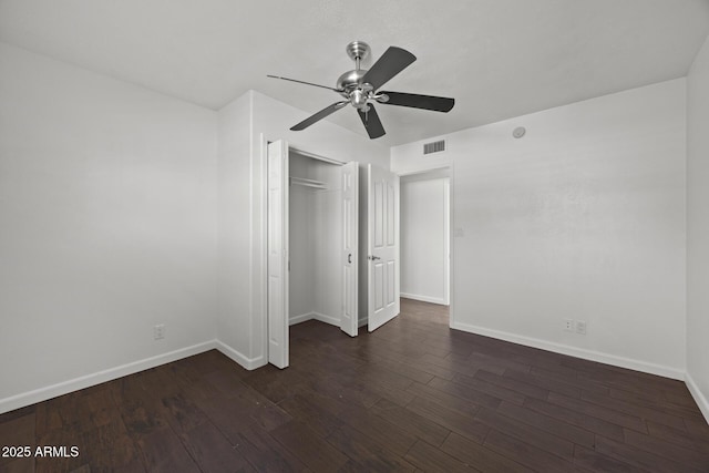 unfurnished bedroom with dark hardwood / wood-style flooring, a closet, and ceiling fan