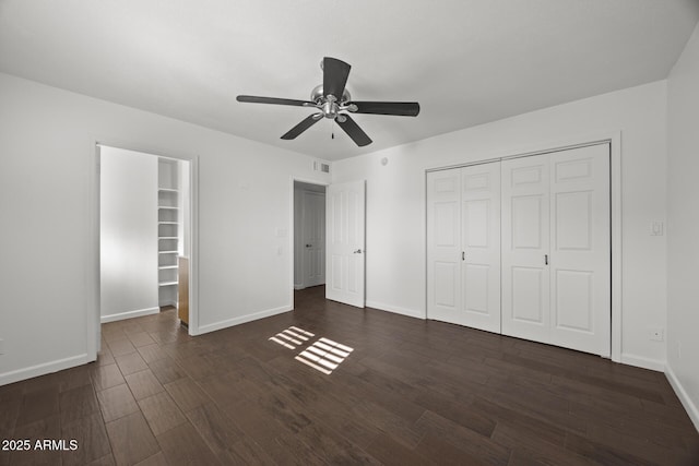 unfurnished bedroom featuring ceiling fan, dark wood-type flooring, and a closet