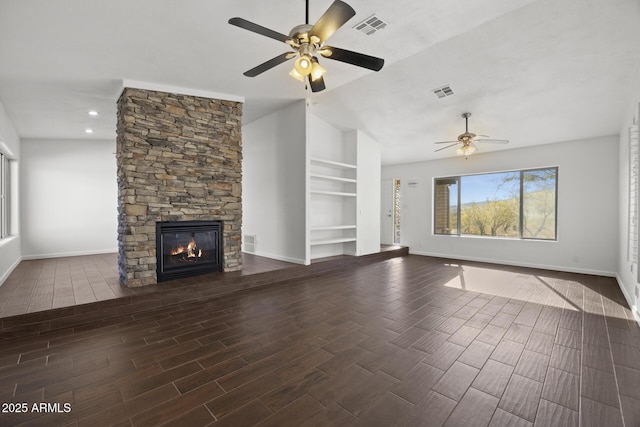 unfurnished living room with a fireplace, vaulted ceiling, built in features, and ceiling fan