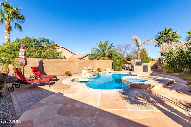 view of pool featuring a patio area, an in ground hot tub, and exterior kitchen