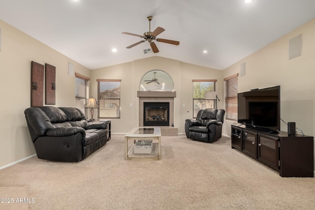 carpeted living room with lofted ceiling, a tile fireplace, and ceiling fan