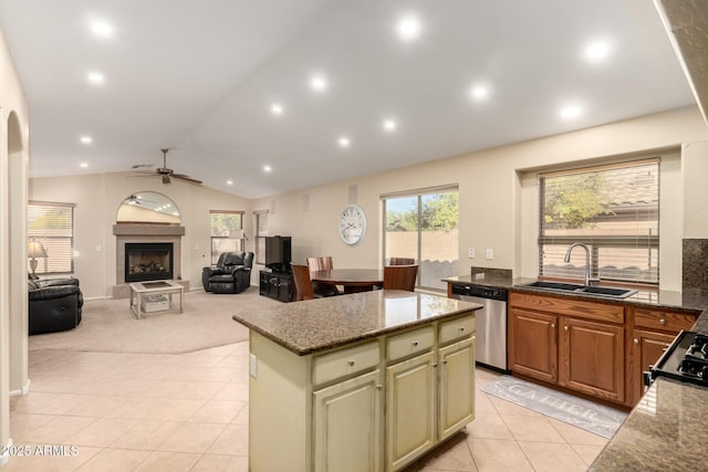 kitchen featuring sink, stove, a center island, stainless steel dishwasher, and light stone counters