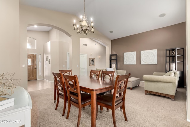 dining room featuring light carpet and high vaulted ceiling