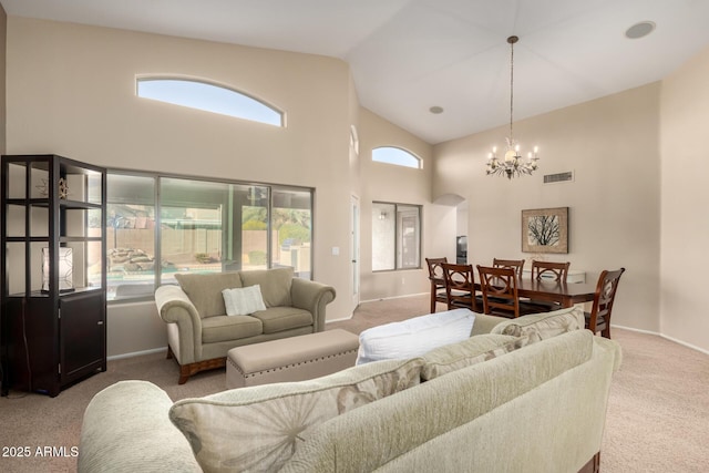 living room with high vaulted ceiling, carpet flooring, and a chandelier