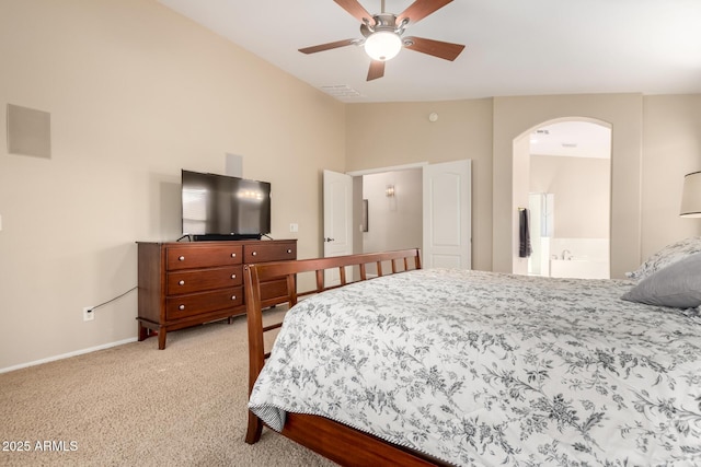 bedroom featuring vaulted ceiling, light colored carpet, ceiling fan, and ensuite bathroom