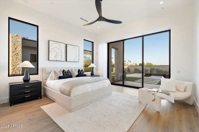 bedroom featuring access to outside, light hardwood / wood-style flooring, and multiple windows