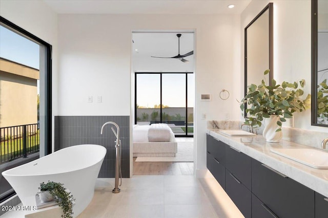 bathroom featuring tile patterned floors, a tub, plenty of natural light, and vanity