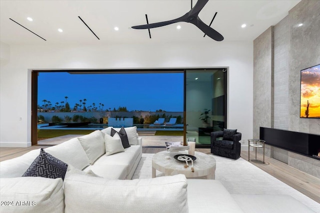 living room with light hardwood / wood-style flooring and ceiling fan