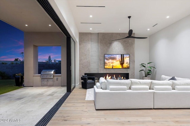 living room featuring a large fireplace and light hardwood / wood-style flooring