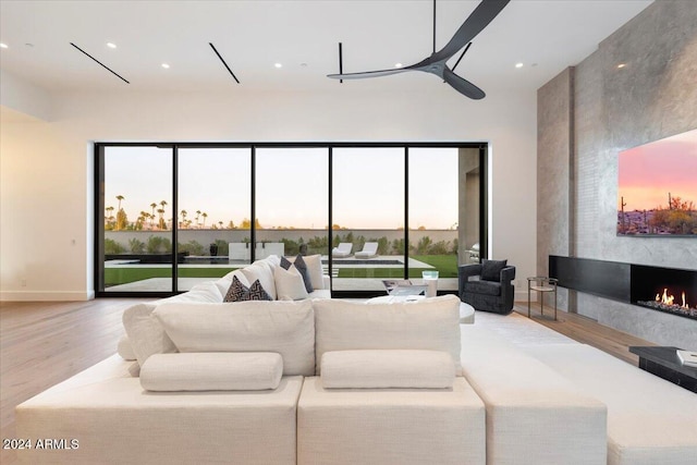 living room with hardwood / wood-style floors, a healthy amount of sunlight, and a premium fireplace