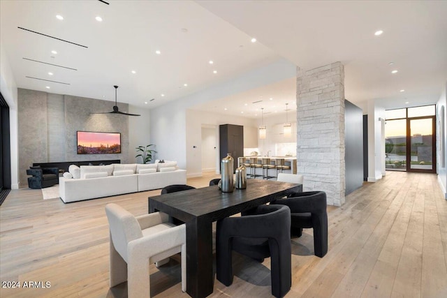 dining space featuring ceiling fan, light hardwood / wood-style flooring, and decorative columns