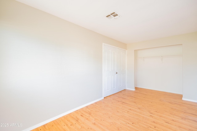 17824 E Chestnut Dr, Queen Creek, AZ 85142 - unfurnished bedroom featuring light wood finished floors, baseboards, visible vents, and a closet