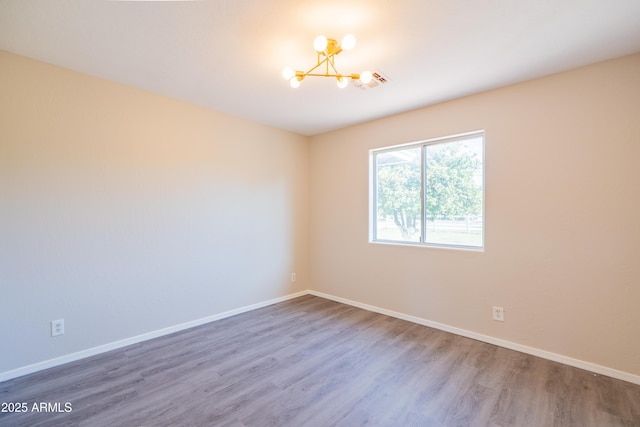 17824 E Chestnut Dr, Queen Creek, AZ 85142 - spare room with baseboards, wood finished floors, and a chandelier