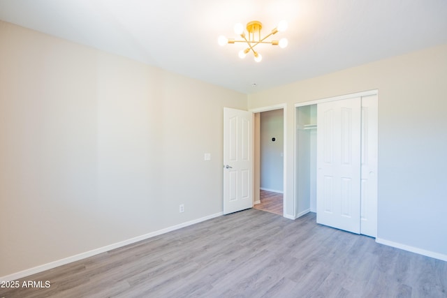 17824 E Chestnut Dr, Queen Creek, AZ 85142 - unfurnished bedroom with light wood finished floors, baseboards, an inviting chandelier, and a closet