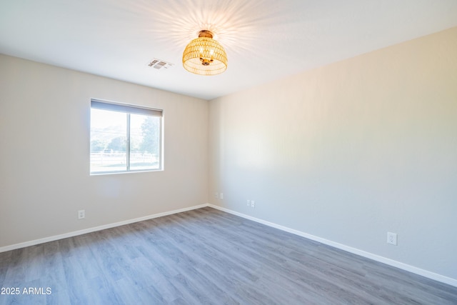17824 E Chestnut Dr, Queen Creek, AZ 85142 - unfurnished room featuring wood finished floors, visible vents, baseboards, and a notable chandelier