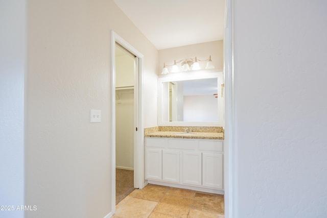 17824 E Chestnut Dr, Queen Creek, AZ 85142 - bathroom featuring a walk in closet, baseboards, and vanity