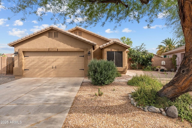 11405 W Windsor Ave, Avondale, AZ 85392 - view of front of house featuring driveway, an attached garage, stucco siding, a tile roof, and fence