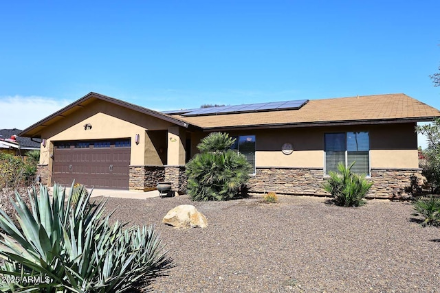 view of front facade with stone siding, stucco siding, an attached garage, and solar panels