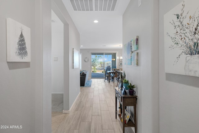 corridor featuring light wood-style floors, baseboards, visible vents, and recessed lighting