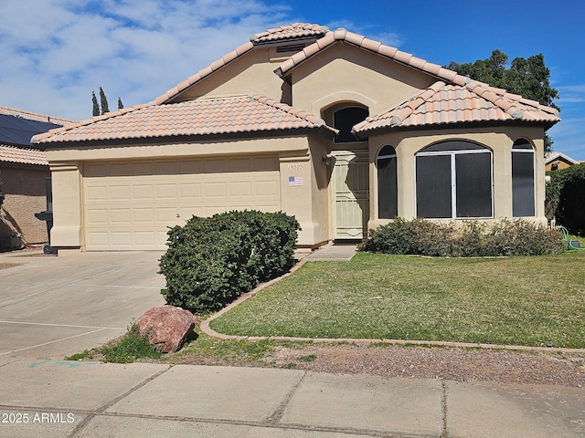 mediterranean / spanish-style house featuring driveway, stucco siding, a front lawn, a garage, and a tile roof