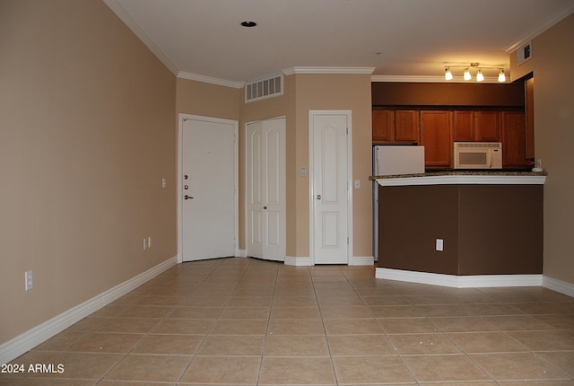 kitchen featuring light tile patterned flooring, crown molding, and white appliances