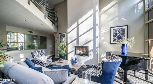 living area with a high ceiling, a fireplace, and visible vents