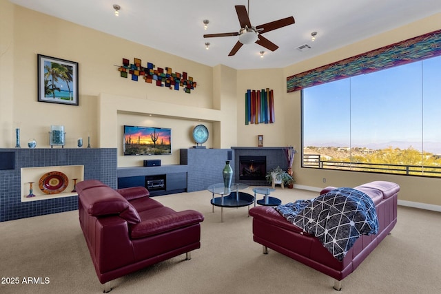 carpeted living room with a brick fireplace and ceiling fan