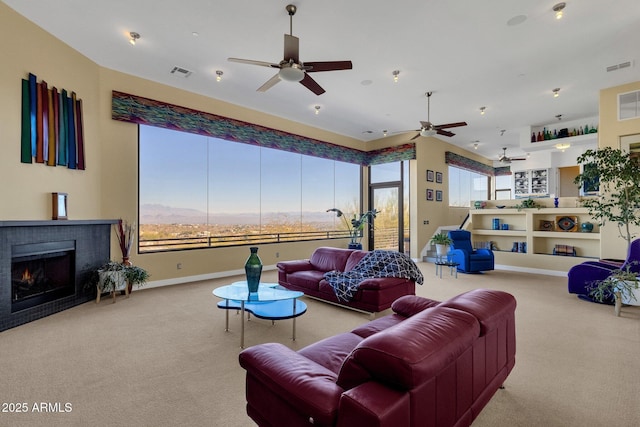 carpeted living room featuring a wealth of natural light and ceiling fan