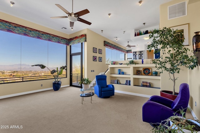 sitting room with carpet, a mountain view, ceiling fan, and a wealth of natural light