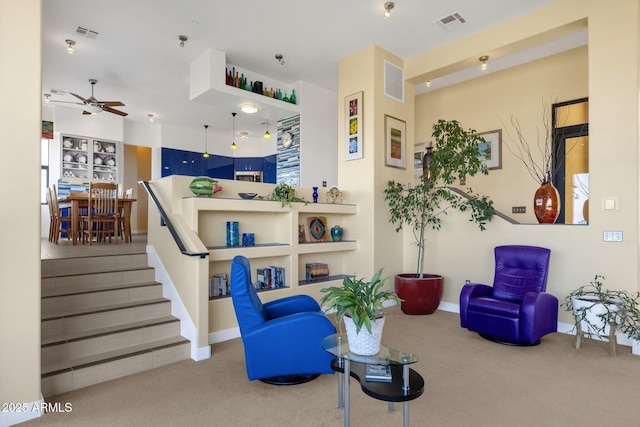 living room with ceiling fan and carpet