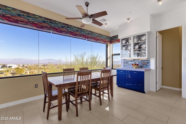 tiled dining area with a mountain view and ceiling fan