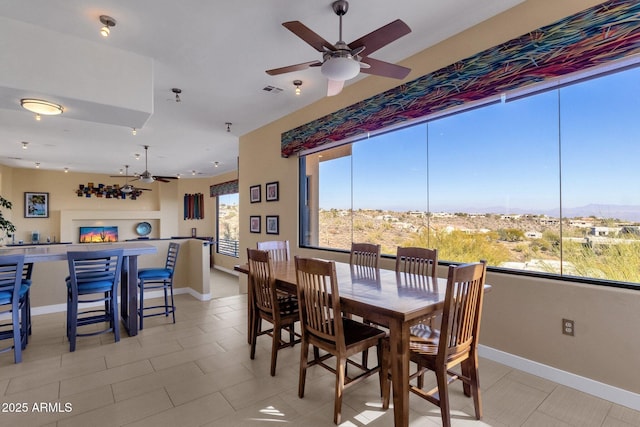 tiled dining space with a mountain view, plenty of natural light, and ceiling fan