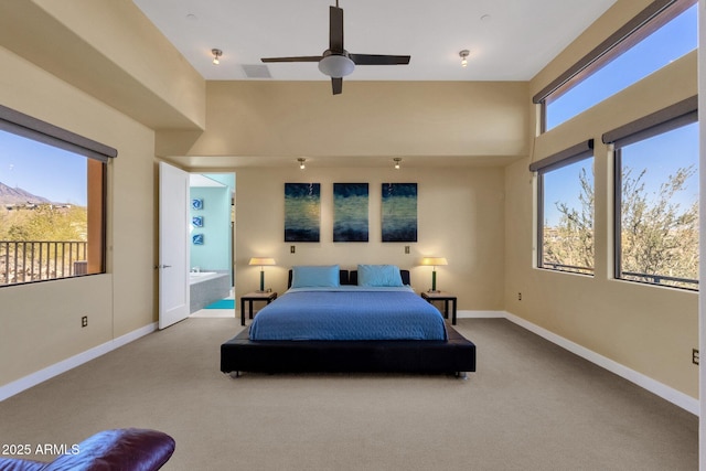 bedroom with ceiling fan, carpet floors, multiple windows, and ensuite bath