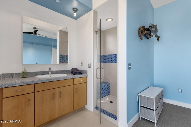 bathroom with tile patterned floors, ceiling fan, vanity, and a shower with shower door