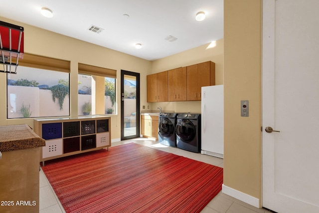 laundry room featuring cabinets, light tile patterned floors, separate washer and dryer, and sink