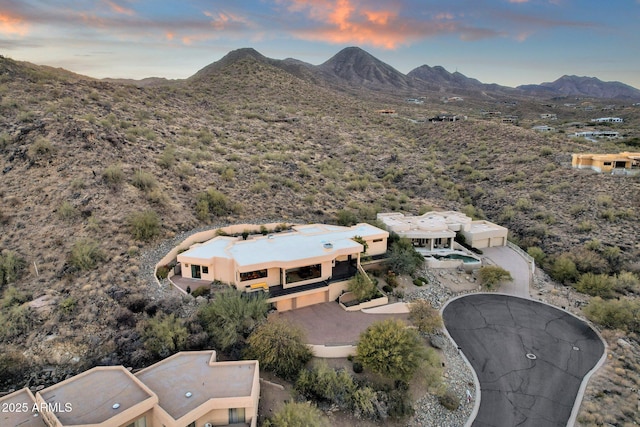 aerial view at dusk featuring a mountain view