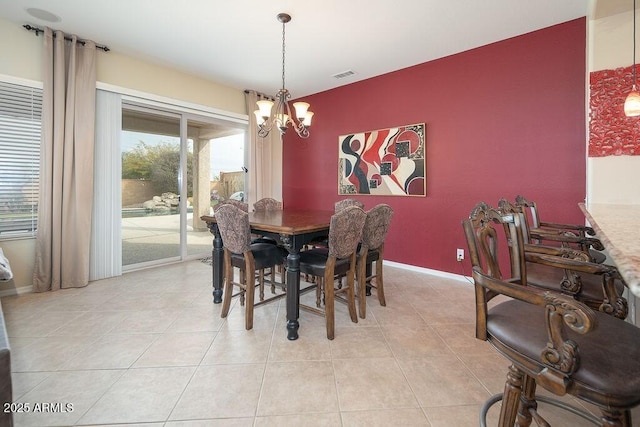 dining area featuring a chandelier and light tile patterned flooring