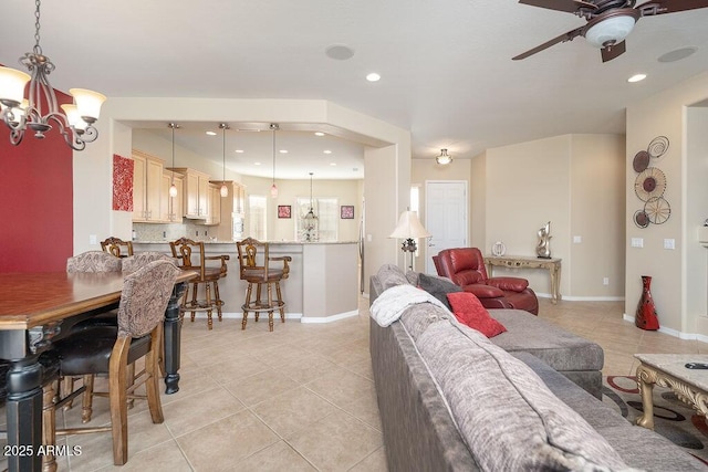 tiled living room with ceiling fan with notable chandelier